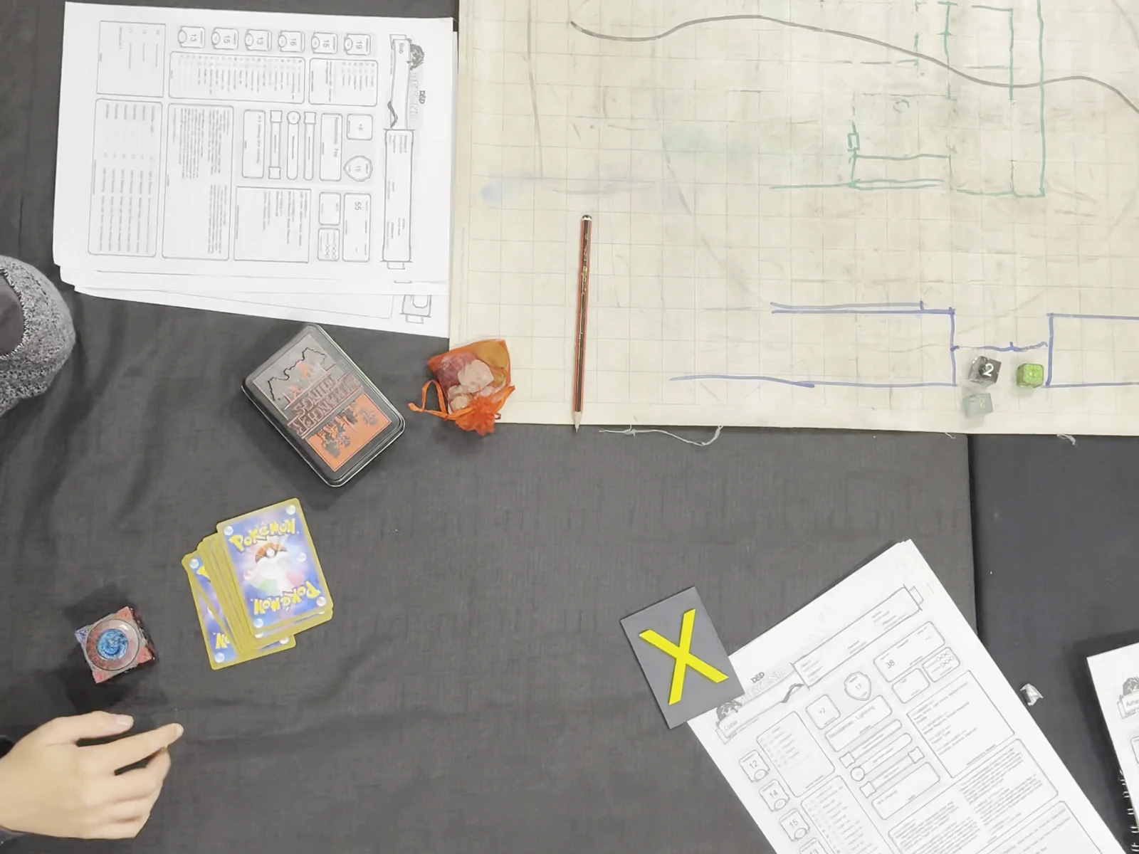 Character sheets, a hand-drawn battle map and session notes laid out before play